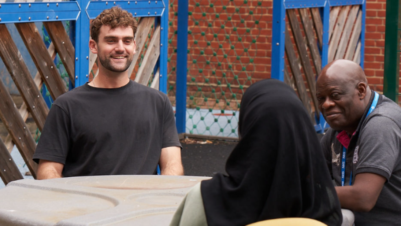 A man speking with staff at a wellbeing centre